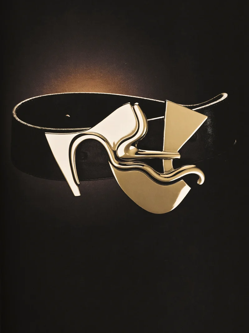 Studio illustrato di cintura in pelle scultorea con fibbia astratta originale.